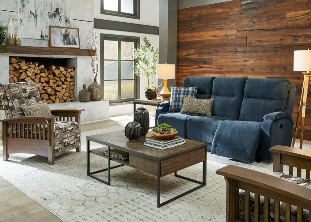 Living room with blue sofa, wooden chairs, and a fireplace.
