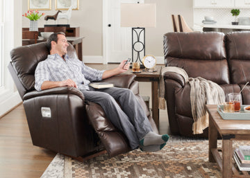 Man relaxing in a brown La-Z-boy recliner chair in a living room setting.